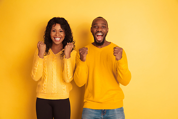 Image showing Young emotional african-american man and woman on yellow background