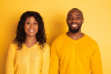 Image showing Young emotional african-american man and woman on yellow background