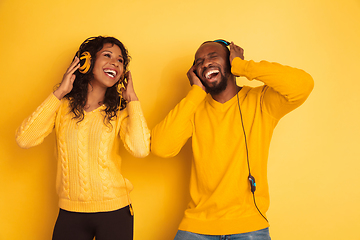 Image showing Young emotional african-american man and woman on yellow background