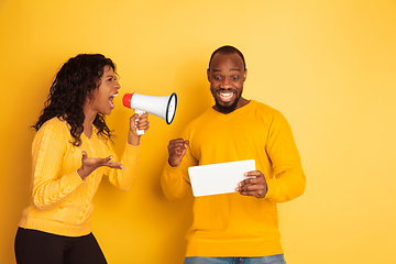 Image showing Young emotional african-american man and woman on yellow background