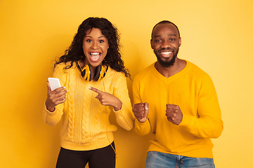 Image showing Young emotional african-american man and woman on yellow background