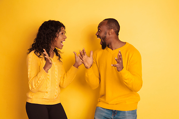 Image showing Young emotional african-american man and woman on yellow background