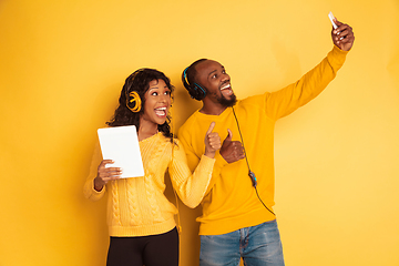 Image showing Young emotional african-american man and woman on yellow background