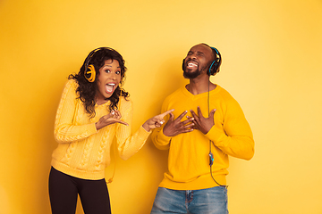 Image showing Young emotional african-american man and woman on yellow background