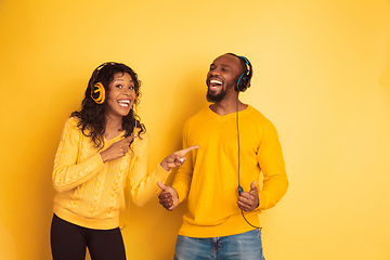 Image showing Young emotional african-american man and woman on yellow background