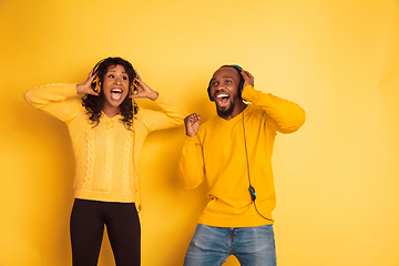 Image showing Young emotional african-american man and woman on yellow background