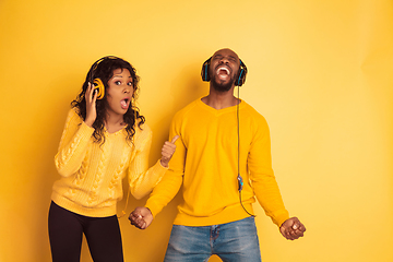 Image showing Young emotional african-american man and woman on yellow background