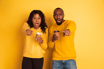 Image showing Young emotional african-american man and woman on yellow background