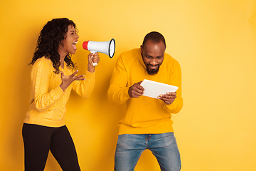 Image showing Young emotional african-american man and woman on yellow background