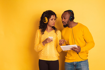 Image showing Young emotional african-american man and woman on yellow background