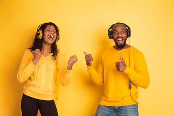 Image showing Young emotional african-american man and woman on yellow background