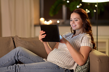 Image showing happy pregnant woman with tablet pc at home