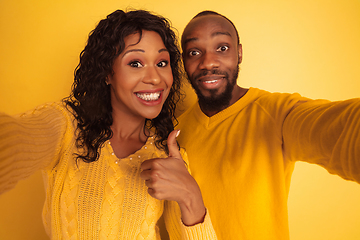 Image showing Young emotional african-american man and woman on yellow background