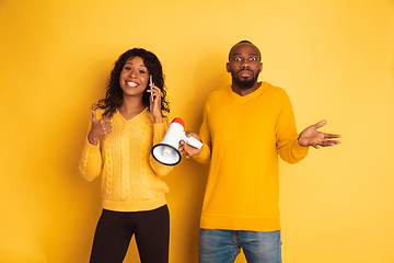 Image showing Young emotional african-american man and woman on yellow background