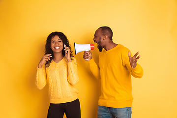 Image showing Young emotional african-american man and woman on yellow background