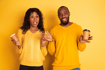 Image showing Young emotional african-american man and woman on yellow background