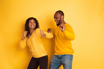 Image showing Young emotional african-american man and woman on yellow background