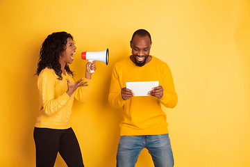 Image showing Young emotional african-american man and woman on yellow background