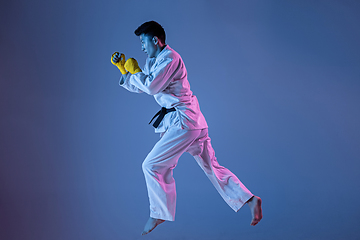 Image showing Confident korean man in kimono practicing hand-to-hand combat, martial arts