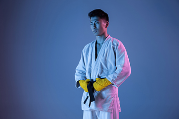 Image showing Confident korean man in kimono practicing hand-to-hand combat, martial arts