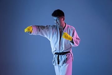 Image showing Confident korean man in kimono practicing hand-to-hand combat, martial arts