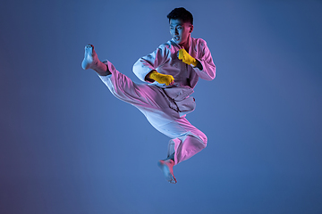 Image showing Confident korean man in kimono practicing hand-to-hand combat, martial arts