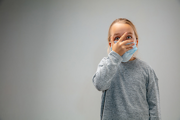 Image showing Caucasian girl wearing the respiratory protection mask against air pollution and dusk on grey studio background