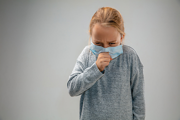 Image showing Caucasian girl wearing the respiratory protection mask against air pollution and dusk on grey studio background