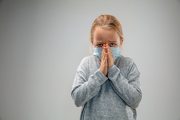 Image showing Caucasian girl wearing the respiratory protection mask against air pollution and dusk on grey studio background