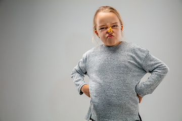 Image showing Caucasian girl wearing the respiratory protection pin clasp against air pollution and dusk on grey studio background