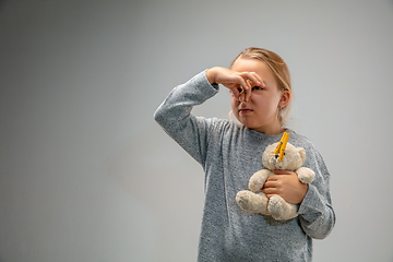 Image showing Caucasian girl wearing the respiratory protection pin clasp against air pollution and dusk on grey studio background