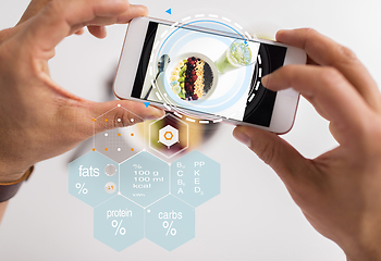 Image showing hands with phone and food nutritional value chart