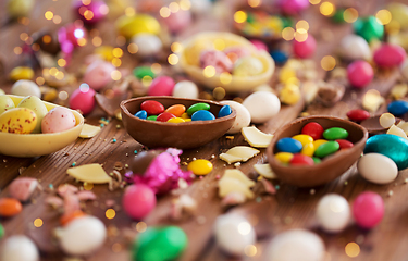 Image showing chocolate eggs and candy drops on wooden table