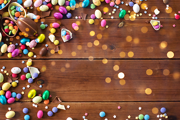 Image showing chocolate eggs and candy drops on wooden table