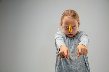 Image showing Caucasian girl wearing the respiratory protection pin clasp against air pollution and dusk on grey studio background