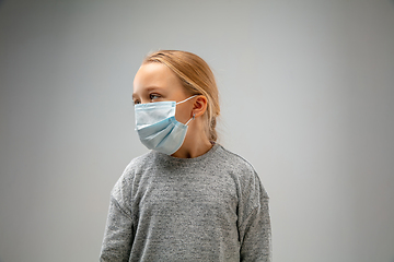 Image showing Caucasian girl wearing the respiratory protection mask against air pollution and dusk on grey studio background