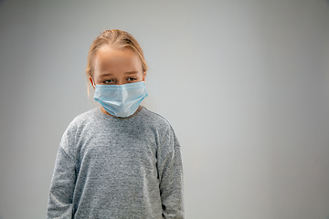 Image showing Caucasian girl wearing the respiratory protection mask against air pollution and dusk on grey studio background