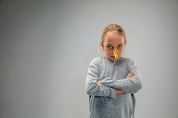 Image showing Caucasian girl wearing the respiratory protection pin clasp against air pollution and dusk on grey studio background