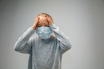 Image showing Caucasian girl wearing the respiratory protection mask against air pollution and dusk on grey studio background