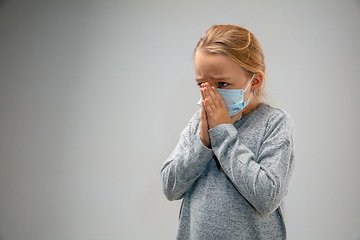 Image showing Caucasian girl wearing the respiratory protection mask against air pollution and dusk on grey studio background