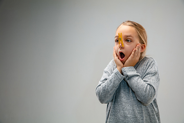 Image showing Caucasian girl wearing the respiratory protection pin clasp against air pollution and dusk on grey studio background