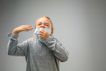 Image showing Caucasian girl wearing the respiratory protection mask against air pollution and dusk on grey studio background