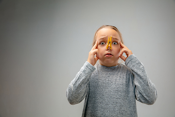 Image showing Caucasian girl wearing the respiratory protection pin clasp against air pollution and dusk on grey studio background