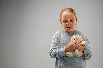 Image showing Caucasian girl wearing the respiratory protection pin clasp against air pollution and dusk on grey studio background