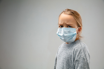 Image showing Caucasian girl wearing the respiratory protection mask against air pollution and dusk on grey studio background