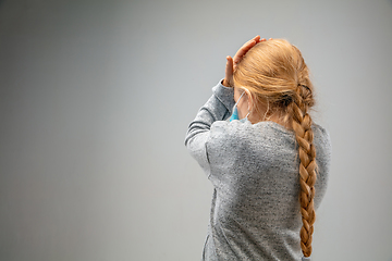 Image showing Caucasian girl wearing the respiratory protection mask against air pollution and dusk on grey studio background