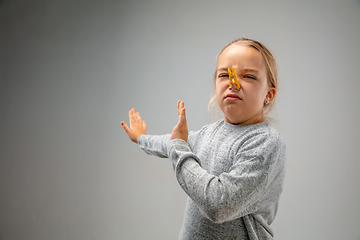 Image showing Caucasian girl wearing the respiratory protection pin clasp against air pollution and dusk on grey studio background