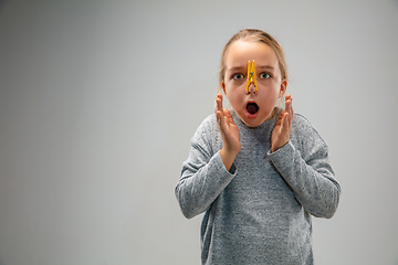 Image showing Caucasian girl wearing the respiratory protection pin clasp against air pollution and dusk on grey studio background