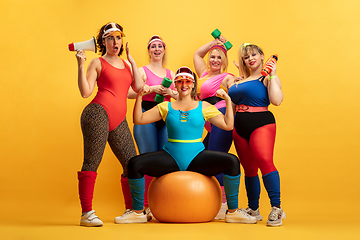 Image showing Young caucasian plus size female models training on yellow background