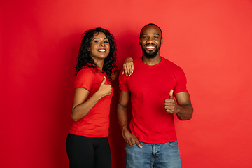 Image showing Young emotional african-american man and woman on red background